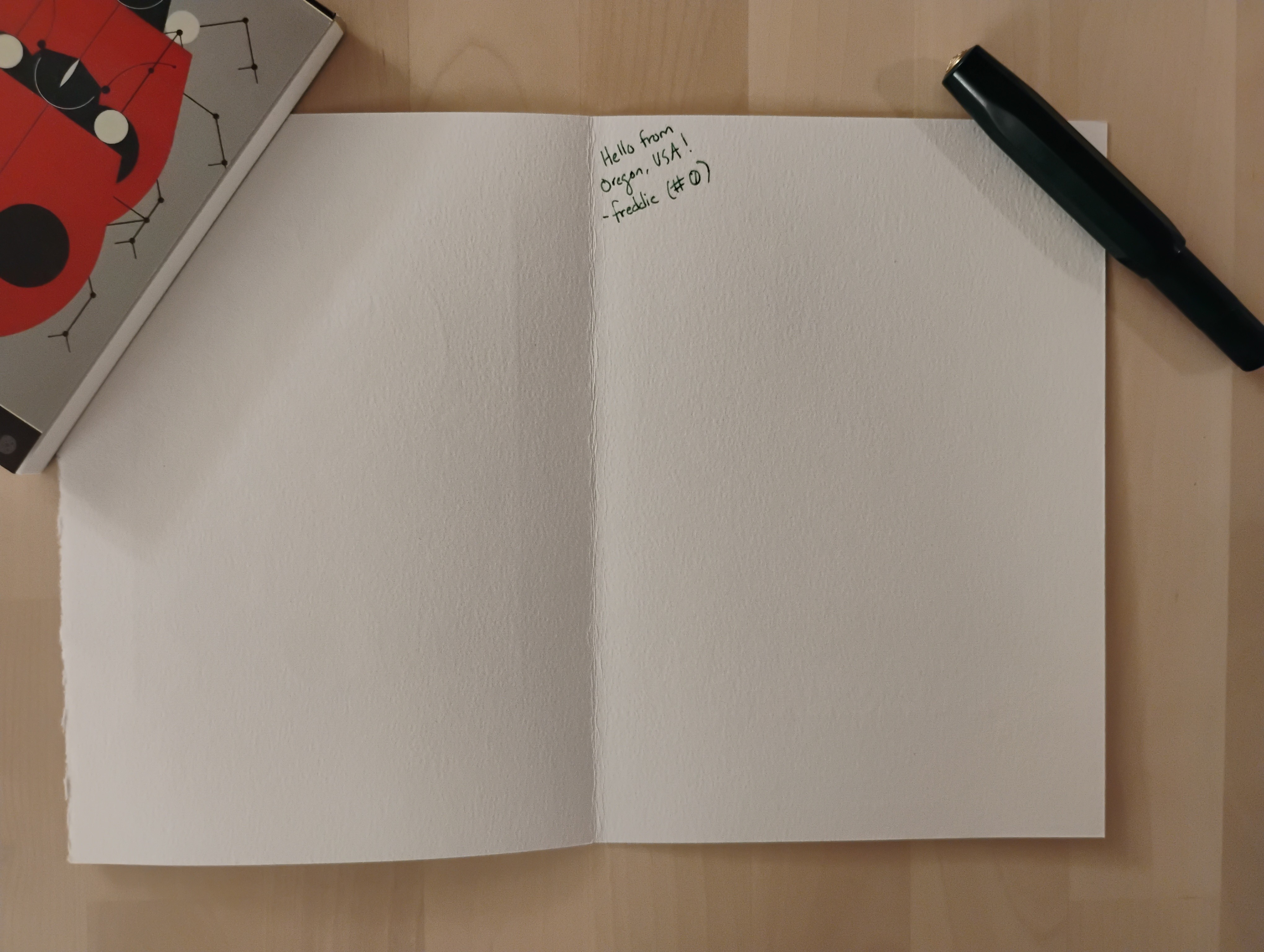 an open greeting card, blank except for some small writing that reads 'Hello from Oregon, USA! -freddie (#0)