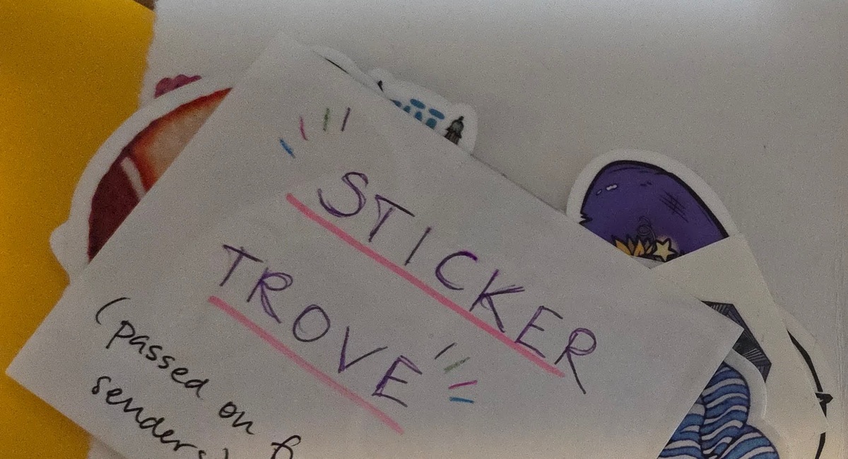 a piece of paper that says in all caps, sticker trove, with a mostly hidden pile of stickers underneath